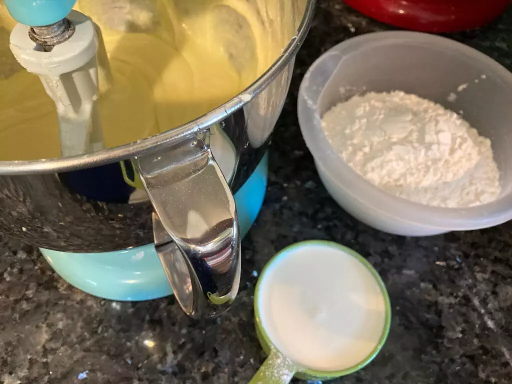 adding flour and whipping cream to cake batter