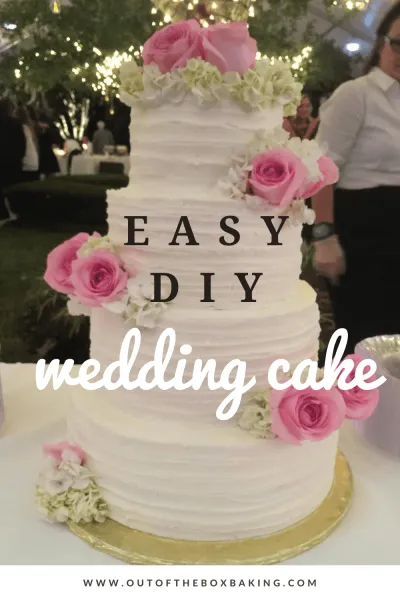 Easy DIY Wedding Cake from outoftheboxbaking.com - image of four tiered white wedding cake with pink flowers