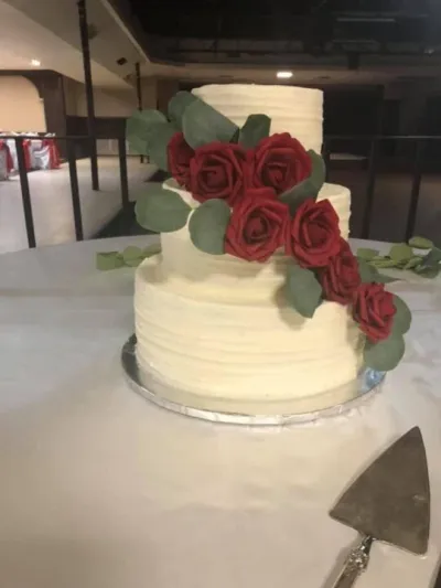 simple three-tiered wedding cake with maroon roses