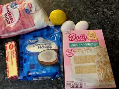 ingredients for Dolly Parton coconut cake mix including coconut cake mix, coconut flakes, butter, eggs, lemon, powdered sugar