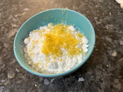 powdered sugar, lemon, and zester in bowl