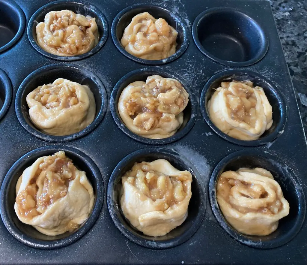 bananas foster cinnamon rolls in muffin tin